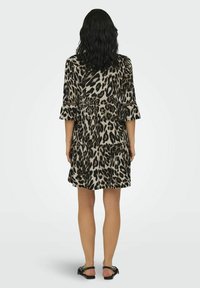 Robe à imprimé léopard en gris et noir, fabriquée dans un tissu doux, avec des manches trois-quarts, une taille cintrée et une jupe évasée.