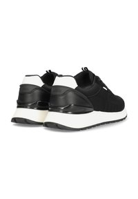 Černé síťové tenisky s bílými akcenty, které mají texturovaný svršek, polstrovaný límec a gumovou podrážku. Logo viditelné na patě.