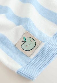 Stribet sweater med lyseblå og hvide farver, lavet af tekstureret stof og med en lappet dekoration, der viser et smilende æbledesign.