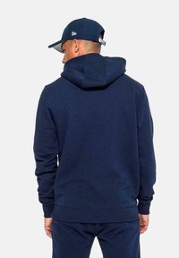 Felpa blu navy con cappuccio, tessuto misto cotone, polsini e orlo a costine, caratterizzata da una vestibilità casual e un design minimalista.