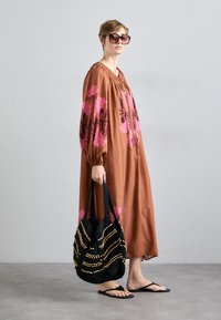 Καφέ, μακρύ φόρεμα με λουλούδια και μακριά μανίκια; μαύρη τσάντα με χάντρες; μαύρες σαγιονάρες; μεγάλα γυαλιά ηλίου. Λείος υφή συνολικά.