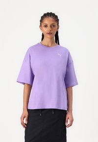 Tricou scurt cu maneci, de culoare purpurie, cu guler rotund și croială relaxată, având un mic logo alb Puma pe partea stângă a pieptului. Textură netedă a țesăturii.