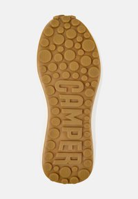 Sole di una scarpa Camper, caratterizzata da una gomma marrone testurizzata con motivi circolari e ondulati, etichettata "38" e "CAMPER."