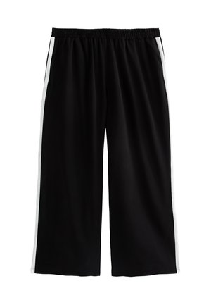 Pantalons larges noirs avec une taille élastique, présentant des rayures latérales blanches et une texture de tissu lisse et léger.
