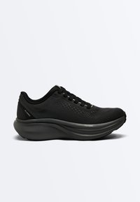 Chaussure de sport basse noire avec tige en maille, semelle épaisse et rembourrée étiquetée "Freefoam", et lacets, présentée en profil latéral sur fond blanc.