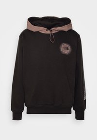 Sudadera negra con capucha marrón claro, cordón ajustable, parche con logo en el pecho y detalles gráficos en la manga.