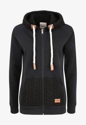 Crna dukserica s patentnim zatvaračem s teksturiranim prednjim džepom u kabel pletenici, kontrastnom crnom unutrašnjošću kapuljače i kremastim vezicama s kožnim završecima.