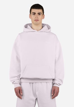 Sudadera con capucha de color rosa claro, hecha de tela suave. Cuenta con un bolsillo canguro en la parte delantera, puños acanalados y un pequeño logo en el pecho.