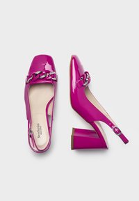 Tacchi slingback in pelle verniciata rosa con punta quadrata, dettaglio in catena metallica e tacco spesso. Interno con soletta beige.