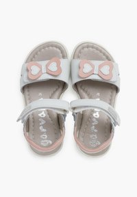 Sandalias grises y rosas con un lazo en forma de corazón, tiras sintéticas, velcro ajustable y plantilla acolchada. Suela plana de goma.