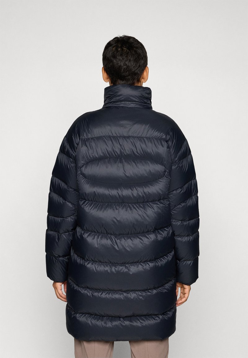 Marineblå puffjakke med høj krave, der har et quiltet design og vandrette syninger. Stoffet ser blankt og glat ud og tilbyder en afslappet pasform.