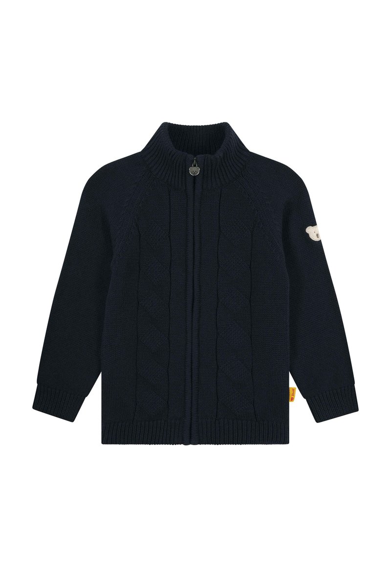 Marine gebreide cardigan met hoge kraag, volledige ritssluiting, kabelpatroon en een berenembleem op de linkermouw. Geribde manchetten en zoom.