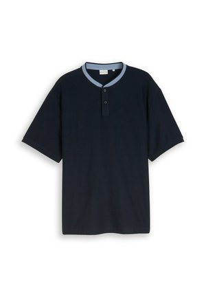 Chemise bleu marine à manches courtes avec col contrastant bleu clair et deux boutons sous l'encolure, posée à plat sur un fond blanc.