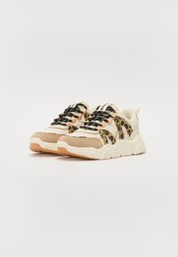 Sneakers con una combinazione di suede beige e mesh con dettagli in stampa leopardata, lacci neri e una suola bianca a motivo ondulato.