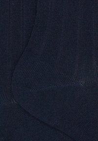 Calze a coste di un blu navy scuro realizzate in un tessuto morbido e elasticizzato. Presentano una superficie liscia con un motivo solido e uniforme.