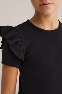 Černé žebrované tričko s krátkým rukávem, které má řasený detail na levém rameni, s kulatým výstřihem a hladkým povrchem.