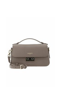 Lacoste handbag in textured taupe material with a flap closure, gold accents, and a detachable shoulder strap. Features a sleek design.