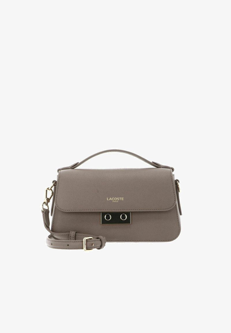 Lacoste handbag in textured taupe material with a flap closure, gold accents, and a detachable shoulder strap. Features a sleek design.