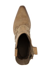 Botines de ante color canela con punta afilada, costuras decorativas y tirador. Textura suave con un ligero brillo y detalles hardware mínimos.