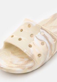Sandal in cavallo chiaro in materiale testurizzato con motivo marmorizzato, dotato di perforazioni sulla cinghia e di una soletta decorata.
