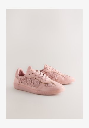 Roosad tossud, mille külgedel on tekstureeritud lillemustriga ja ülaosas sile nahk ning paelaga kinnitused. Omavad kummist tallaga.