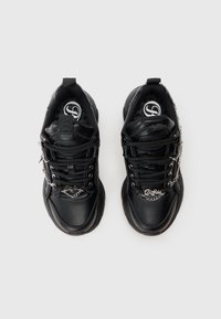 Zwarte leren sneakers met platte veters, gewatteerde kraag, zilveren kettingdetails en een gestructureerde zool. Logo zichtbaar binnenin de schoen.