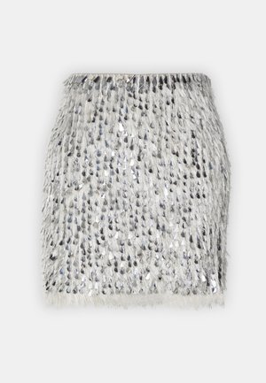 Frufru mini szoknya ezüst flitteres díszítéssel világos szövet háttéren. Egyenes sziluettel és puha textúrával rendelkezik.