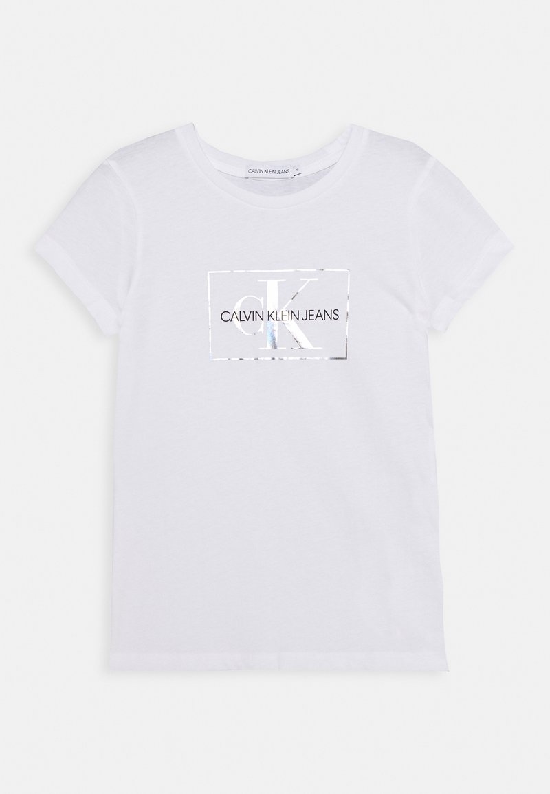 Bílý bavlněný tričko s kulatým výstřihem, na kterém je velké černé obdélníkové logo s nápisem "CALVIN KLEIN JEANS" a zrcadlovými akcenty.