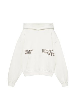 Hoodie blanc avec poche kangourou et texte marron indiquant "BECOMING BOLDER" et "CREATORS STUDIO NYC" sur la poitrine.
