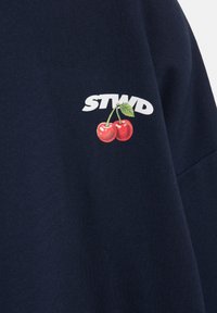 Sötétkék pulóver fehér "STWD" felirattal és egy részletgazdag stílusban ábrázolt két piros cseresznye zöld levelekkel.