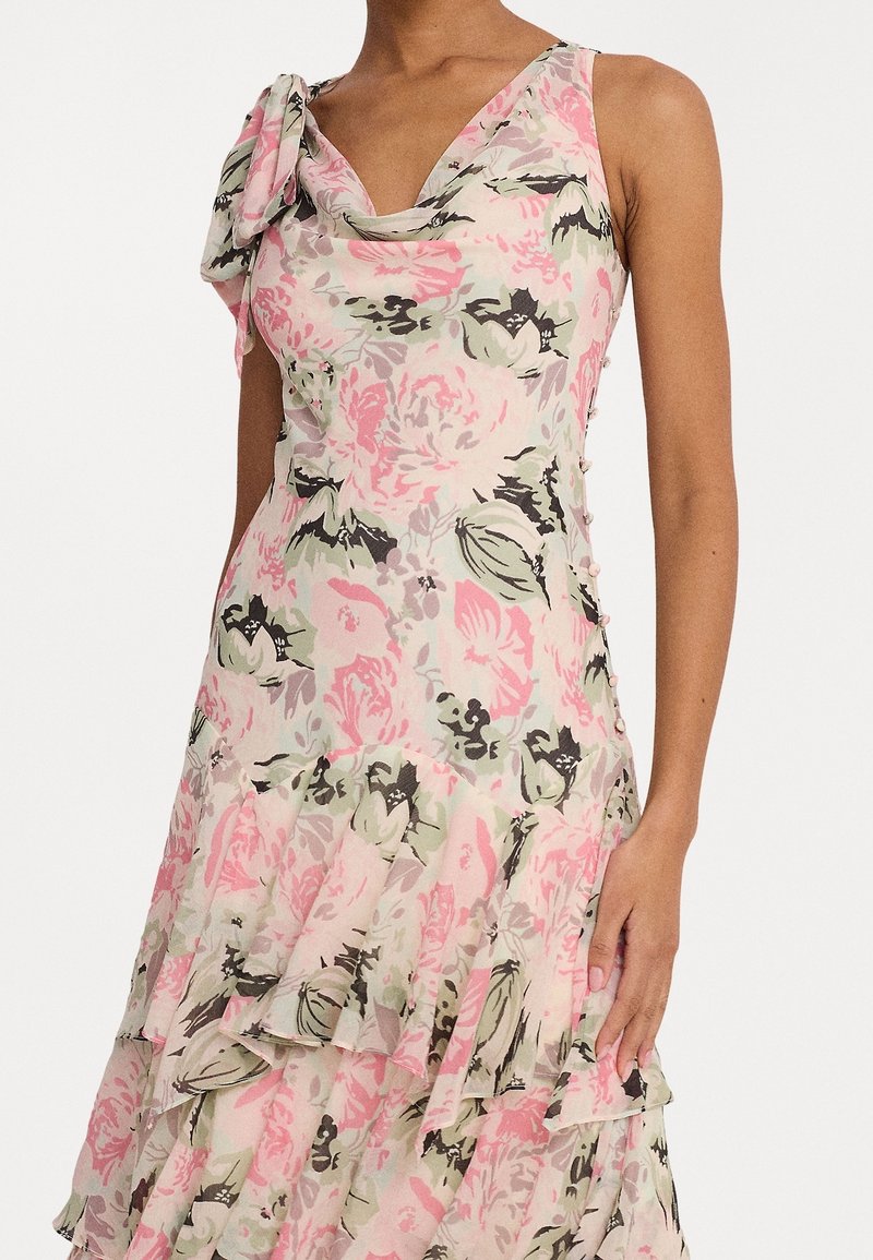 Floral print dress in pastel shades of pink, green, and black. Features a draped neckline, ruffled layers, and button details on the side.