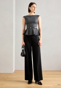 Grå pinstripe peplum topp med kapslermer, beltevirksomhet, kombinert med høyt liv sorte vide bukser og sorte hælede sko.