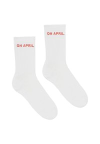Baltas kokvilnas zeķes ar ribotu tekstūru, uz augšējās puses ir drukātais teksts "OH APRIL" korallkrāsā.