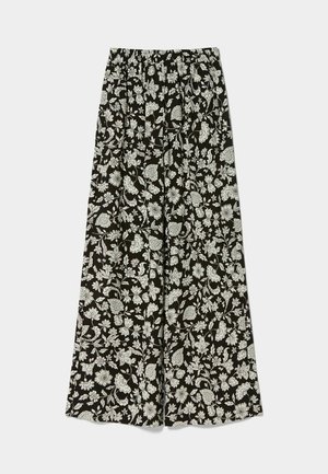 Pantalones amplios negros con un patrón floral blanco, cintura elástica y tejido fluido para mayor comodidad y libertad de movimiento.