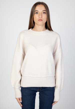 Lys beige strikket sweater med ribbet kant og manchetter, har en afslappet pasform og blødt, tekstureret stof. Lange ærmer og rund hals design.