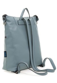 Zaino verticale in pelle di un morbido blu chiaro, con cinghie sottili, manico superiore e chiusura a zip. Include dettagli e cuciture nere.