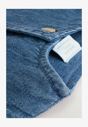 Chaqueta de mezclilla para bebé en azul profundo; presenta un cuello redondeado, detalles de costura y una etiqueta visible. El material tiene un acabado suave y texturizado.