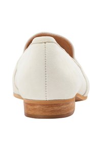 Pantofi plat bej deschis din suede, cu spatele rotund și un toc mic din lemn. Au cusături vizibile de-a lungul cusăturilor.