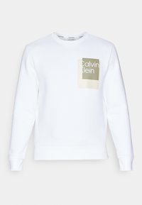 Sudadera blanca con cuello redondo, puños y dobladillo acanalados. Presenta un logo rectangular en verde claro y beige en la parte delantera.