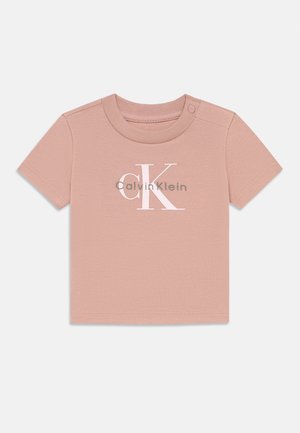 Rózsaszín, rövid ujjú póló puha pamutból, kiemelkedő fehér "CK" logóval és "Calvin Klein" felirattal. Nyomógombos záródás a vállon.