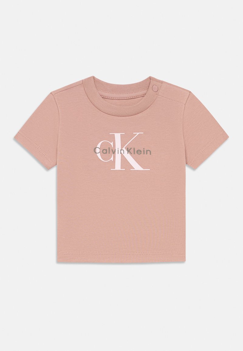 Rosa kortermet T-skjorte i myk bomull, med en fremtredende hvit "CK" logo og tekst "Calvin Klein". Trykknappstenging på skulderen.