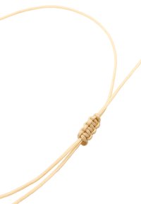 Collana in corda beige regolabile con un dettaglio centrale annodato, superficie liscia e sottili filamenti intrecciati che si estendono dal nodo.