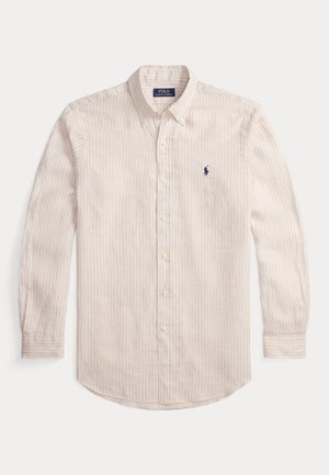 Koszula z guzikami w jasnobeżowym kolorze z cienkimi pionowymi paskami. Bawełniana tkanina, długie rękawy, zaokrąglony dół oraz małe haftowane logo w kolorze granatowym.