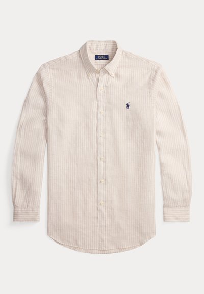 Πουκάμισο με κουμπιά στο μπροστινό μέρος σε ανοιχτό μπεζ χρώμα με λεπτές κάθετες ρίγες. Βαμβακερό ύφασμα, μακριά μανίκια, στρογγυλεμένο τελείωμα και μικρό κεντημένο λογότυπο σε ναυτικό μπλε χρώμα.