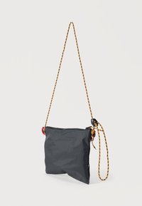 Μαύρη τσάντα ώμου από νάιλον με υφή, κλείσιμο με φερμουάρ και πολύχρωμο πλεκτό λουρί με κόκκινες και κίτρινες λεπτομέρειες.