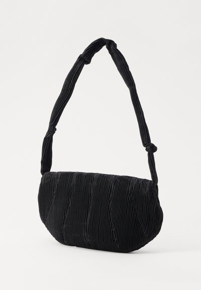 Borsa a spalla in tessuto nero testurizzato con forma rettangolare arrotondata e tracolla imbottita annodata su un lato.