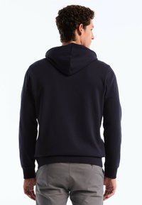 Sweat à capuche bleu marine en mélange de coton doux. Dispose d'une capuche confortable, de poignets côtelés et d'un ourlet droit. Pas de marques ou de motifs visibles.