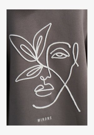 Szary materiał z białym haftowanym konturem twarzy i liścia. Tekst "MIRONS" jest wyhaftowany poniżej wzoru. Gładka faktura, minimalistyczny styl.