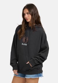 Czarna bluza z kapturem, z kieszenią z przodu, kapturem z sznurkiem i kolorowym wzorem logo. Wykonana z miękkiego materiału o luźnym kroju.