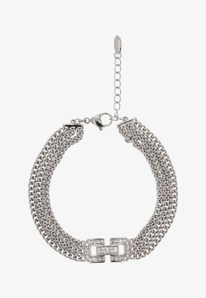 Ezüst színű fém karkötő, több lánc szálból áll, téglalap alakú kapoccsal, amelyet tiszta kövek díszítenek, és állítható lánc hosszabbítóval rendelkezik.